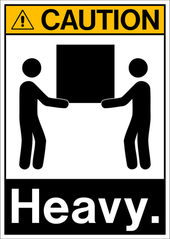 A caution sign featuring a black and white pictogram of two people lifting a heavy object, with the word 'CAUTION' and 'HEAVY.'.