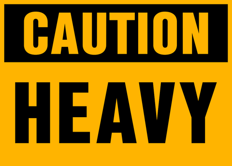 A yellow sign with the words 'CAUTION HEAVY' in black capital letters.