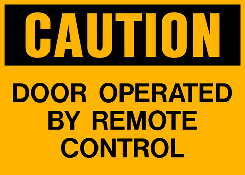 A yellow sign with black text saying 'CAUTION DOOR OPERATED BY REMOTE CONTROL'.