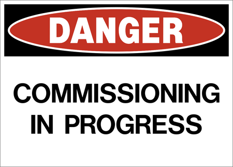 Danger Commissioning in Progress sign with red danger header and bold black text on a white background.