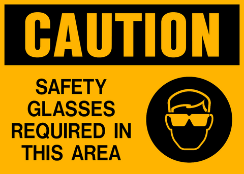 A yellow safety sign with black text and icon indicating 'CAUTION SAFETY GLASSES REQUIRED IN THIS AREA' along with a pictogram of a person wearing sunglasses.