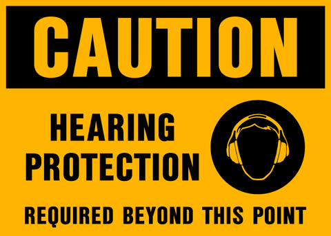 A yellow safety sign with black text and icon indicating 'CAUTION HEARING PROTECTION REQUIRED BEYOND THIS POINT' along with a pictogram of headphones.