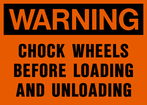 A warning sign with an orange background and black text that reads 'CHOCK WHEELS BEFORE LOADING AND UNLOADING'.